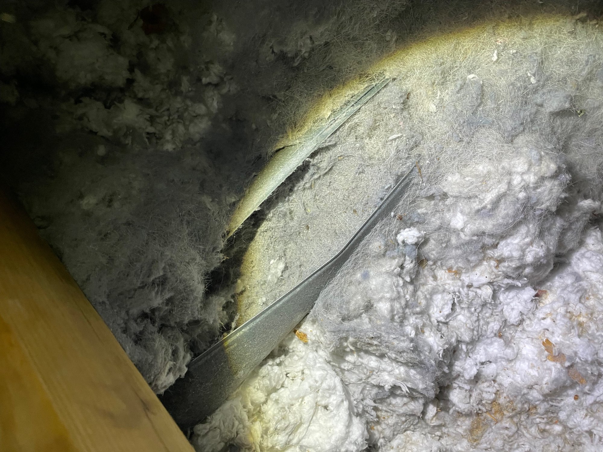 Disconnected dryer vent discovered in attic — lint visible around separated joint